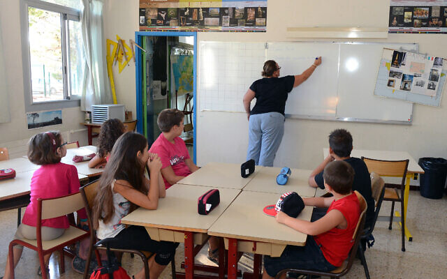 Des écoliers écoutent Isabelle Coulaud (C), directrice de l'école élémentaire Plan de la Cour, à Vitrolles, le 27 août 2012, lors d'une rentrée des classes anticipée pour des élèves entrant en CM1 et CM2 qui participent à de stages de remise à niveau à destination des écoliers présentant, des difficultés en français et en mathématiques. AFP PHOTO / GERARD JULIEN (Photo by GERARD JULIEN / AFP)