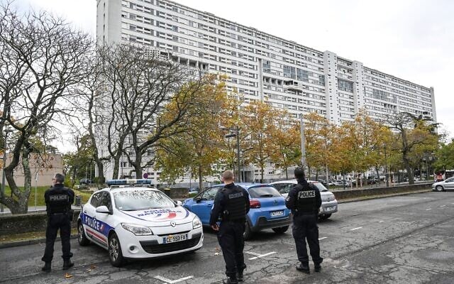 Des policiers français montent la garde près d'un immeuble dans le quartier de Duchère à Lyon, le 26 octobre 2021. 
(Crédit : PHILIPPE DESMAZES / AFP)