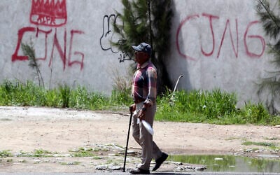 Les initiales du cartel de la drogue « Jalisco Nueva Generacion » (CJNG) taguées sur un mur à Lagos de Moreno, dans l'État de Jalisco, au Mexique, le 29 août 2023. Des empreintes de mains ensanglantées sur un mur témoignent de la barbarie qui s'est déroulée dans une maison où cinq jeunes Mexicains ont été torturés et vraisemblablement assassinés par des tueurs à gages du cartel de la drogue. Ces amis d'enfance âgés de 19 à 22 ans, qui ont disparu dans l'État occidental de Jalisco, ont rejoint les plus de 111 000 personnes portées disparues dans ce pays ravagé par la violence, laissant leurs familles craindre le pire. (Crédit : Ulises Ruiz/AFP)