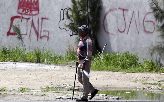 Les initiales du cartel de la drogue « Jalisco Nueva Generacion » (CJNG) taguées sur un mur à Lagos de Moreno, dans l'État de Jalisco, au Mexique, le 29 août 2023. Des empreintes de mains ensanglantées sur un mur témoignent de la barbarie qui s'est déroulée dans une maison où cinq jeunes Mexicains ont été torturés et vraisemblablement assassinés par des tueurs à gages du cartel de la drogue. Ces amis d'enfance âgés de 19 à 22 ans, qui ont disparu dans l'État occidental de Jalisco, ont rejoint les plus de 111 000 personnes portées disparues dans ce pays ravagé par la violence, laissant leurs familles craindre le pire. (Crédit : Ulises Ruiz/AFP)