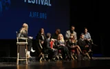 De gauche à droite : Meghan Leathers, Jon Bass, Theo Taplitz, Kyra Sedgwick, Method Man, Milana Vayntrub, Adam Mitchell et Daniel Robbins s’expriment sur scène lors de la première du film Bad Shabbos à l’occasion de la 25ᵉ édition du Festival du film juif d’Atlanta, au Cobb Energy Performing Arts Center, à Atlanta, en Géorgie, le 19 février 2025. (Crédit : Derek White/AFP)