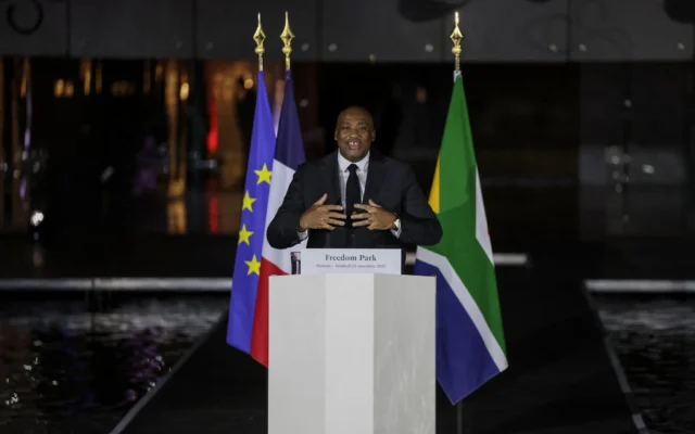 Le ministre sud-africain des Sports, des Arts et de la Culture, Gayton McKenzie (au centre), s'exprime lors d'une cérémonie commémorative en l'honneur des Français qui ont lutté contre l'apartheid, en présence du vice-président sud-africain Paul Mashatile et du président français Emmanuel Macron, au Freedom Park de Pretoria, le 21 novembre 2025, à la veille du sommet des dirigeants du G20. (Crédit :  Ludovic MARIN / AFP)
