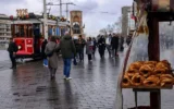 Un vendeur ambulant de petits pains turcs traditionnels ou « Simit » attend les clients sur la place Taksim, à Istanbul, le 27 décembre 2025. (Yasin Akgul/AFP)