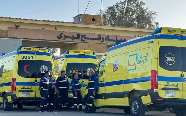 Des ambulanciers égyptiens attendant à côté d'ambulances du côté égyptien du poste-frontière de Rafah avec la bande de Gaza, dans le nord-est de l'Égypte, le 1ᵉʳ février 2026. (Crédit : AFP)