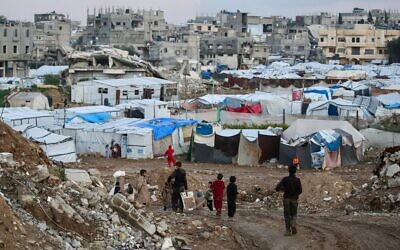 Des enfants passent devant des tentes et des abris de fortune dans le camp de réfugiés de Bureij, dans le centre de la bande de Gaza, le 3 février 2026. (Crédit : Eyad BABA / AFP)