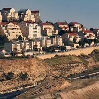 Des véhicules circulant sur une autoroute près de l’implantation de Maale Adumim (en haut), sur une photo prise depuis le « corridor E1 » au nord-est de Jérusalem, en Cisjordanie, le 4 février 2026. (Crédit : Ahmad Gharabli/AFP)