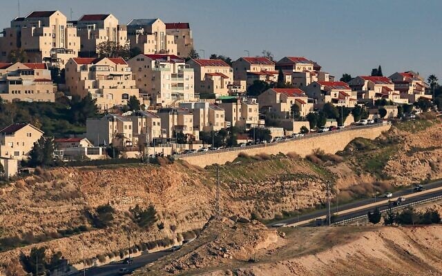 Des véhicules circulant sur une autoroute près de l’implantation de Maale Adumim (en haut), sur une photo prise depuis le « corridor E1 » au nord-est de Jérusalem, en Cisjordanie, le 4 février 2026. (Crédit : Ahmad Gharabli/AFP)