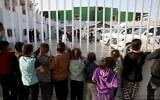 Des enfants regardant des patients se préparer à quitter la bande de Gaza pour se faire soigner via le poste-frontière de Rafah, qui sépare l'enclave de l'Égypte, après sa réouverture par Israël pour un nombre limité de personnes, à Khan Younès, dans le sud de la bande de Gaza, le 8 février 2026. (Crédit : Bashar Taleb/AFP)