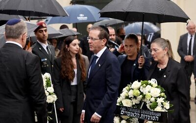 Le président Isaac Herzog (au centre) et son épouse Michal (à droite) arrivant pour déposer une gerbe en hommage aux victimes de la tuerie antisémite du 14 décembre 2025 au Bondi Pavilion, à Sydney, le 9 février 2026. (Crédit : David Gray/AFP)