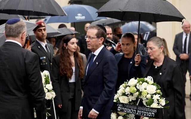 Le président Isaac Herzog (au centre) et son épouse Michal (à droite) arrivant pour déposer une gerbe en hommage aux victimes de la tuerie antisémite du 14 décembre 2025 au Bondi Pavilion, à Sydney, le 9 février 2026. (Crédit : David Gray/AFP)