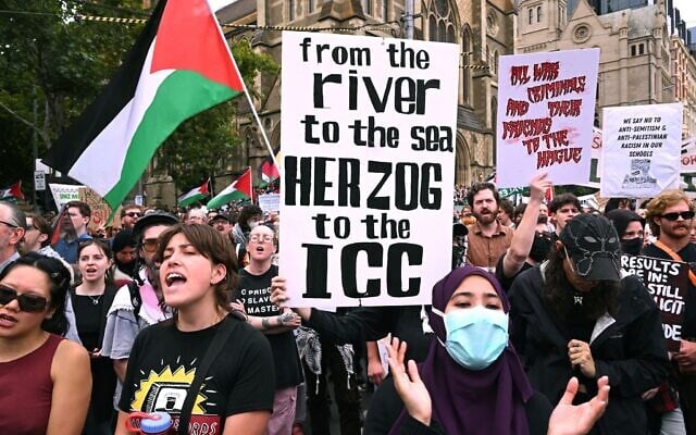 Des personnes brandissant des pancartes lors d'un rassemblement de protestation contre la visite officielle de quatre jours du président Isaac Herzog, à Melbourne, le 9 février 2026. (Crédit : William West/AFP)