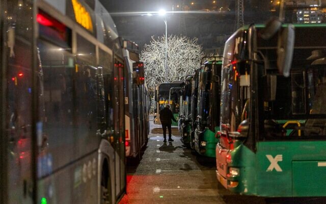 Un chauffeur de bus se dirigeant vers son véhicule devant le stade Teddy lors d'une soirée de match de l'équipe de football Beitar Jerusalem dans le quartier de Malha, à Jérusalem, le 31 janvier 2026. (Crédit : Ilia Yefimovich/AFP)