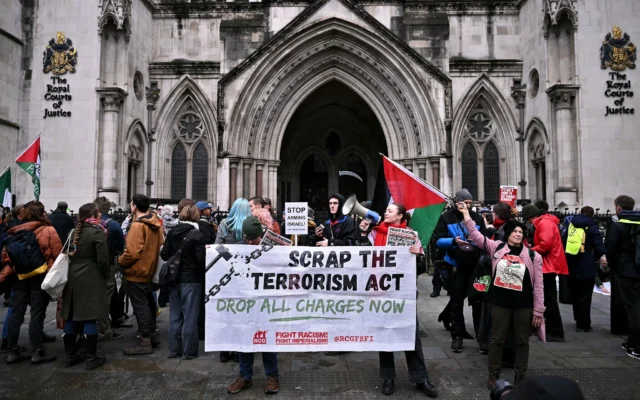 Des manifestants anti-Israël brandissant une banderole en soutien au groupe Palestine Action devant le Royal Courts of Justice, la Haute Cour britannique, à Londres, le 13 février 2026. (Crédit : Ben Stansall/AFP)