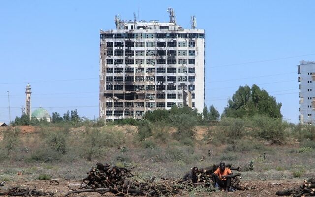 Un Soudanais assis à côté d'un tas de bois de chauffage ramassé dans ce qui reste de la forêt de Sunt, une forêt urbaine composée principalement d'acacias, dans l'un des plus anciens espaces verts de la capitale Khartoum, ravagée par la guerre, le 7 février 2026. (Crédit: Ebrahim Hamid / AFP) Un Soudanais assis à côté d'un tas de bois de chauffage ramassé dans ce qui reste de la forêt de Sunt, une forêt urbaine composée principalement d'acacias, dans l'un des plus anciens espaces verts de la capitale Khartoum, ravagée par la guerre, le 7 février 2026. (Crédit: Ebrahim Hamid / AFP)