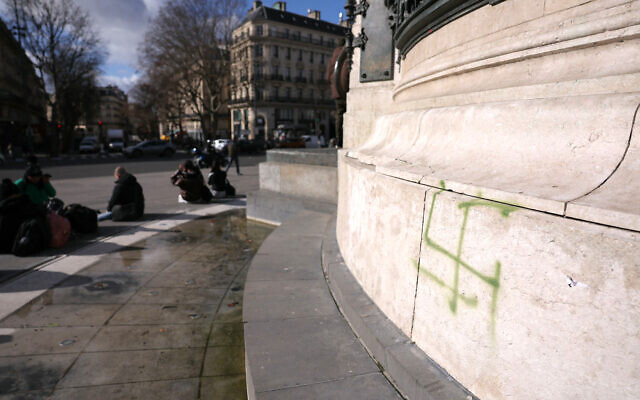 Cette photographie montre un graffiti représentant une croix gammée sur la Statue de la République, place de la République à Paris, le 16 février 2026. (Crédit : Thomas SAMSON / AFP)