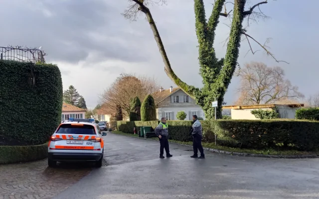 Des policiers montent la garde devant la résidence de l'ambassadeur d'Oman, où se déroulent les négociations indirectes sur le nucléaire entre les États-Unis et l'Iran à Genève, le 17 février 2026. (Crédit : Robin MILLARD / AFP)