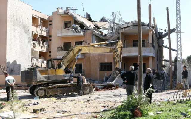 Une excavatrice déblaye les décombres des bâtiments détruits lors des frappes aériennes de l'armée israélienne dans le village d'Ali al-Nahri, au centre de la région de la vallée de la Bekaa, dans l'est du Liban, le 21 février 2026. (Crédit :  AFP)