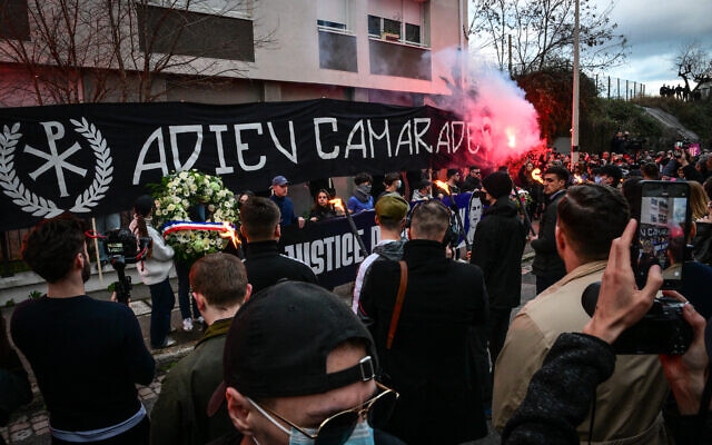Des personnes tenant une banderole sur laquelle on peut lire « Adieu, camarade » à l'endroit même où le militant de droite Quentin Deranque a été lynché à mort, à Lyon, le 21 février 2026. (Crédit : Olivier Chassignole/AFP) Des personnes tenant une banderole sur laquelle on peut lire « Adieu, camarade » à l'endroit même où le militant de droite Quentin Deranque a été lynché à mort, à Lyon, le 21 février 2026. (Crédit : Olivier Chassignole/AFP)