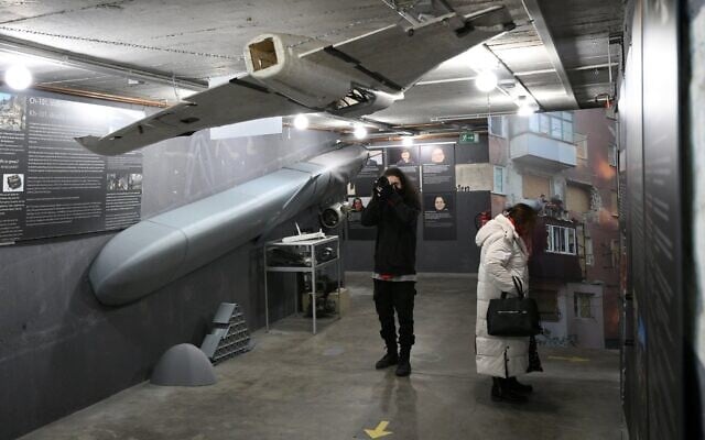 Des visiteurs découvrant les restes d'un missile de croisière russe KH-101 (à gauche) et d'autres objets lors d'une présentation à la presse du « Ukraine Museum » dans le « Berlin Story Bunker », à Berlin, la veille de son ouverture au public et du quatrième anniversaire de l'invasion de l'Ukraine par la Russie, le 23 février 2026. (Crédit : Ralf Hirschberger/AFP)