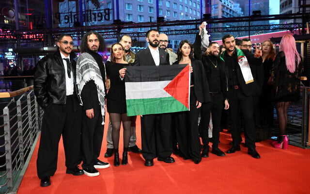 Le réalisateur palestinien Abdallah Alkhatib (2e à gauche) et l'équipe du film "Chronicles From the Siege" avec un drapeau palestinien à leur arrivée sur le tapis rouge de la cérémonie de remise des prix de la 76e Berlinale, le premier grand festival du film européen de l'année, à Berlin, le 21 février 2026. (Crédit : RALF HIRSCHBERGER / AFP) Le réalisateur palestinien Abdallah Alkhatib (2e à gauche) et l'équipe du film "Chronicles From the Siege" avec un drapeau palestinien à leur arrivée sur le tapis rouge de la cérémonie de remise des prix de la 76e Berlinale, le premier grand festival du film européen de l'année, à Berlin, le 21 février 2026. (Crédit : RALF HIRSCHBERGER / AFP)