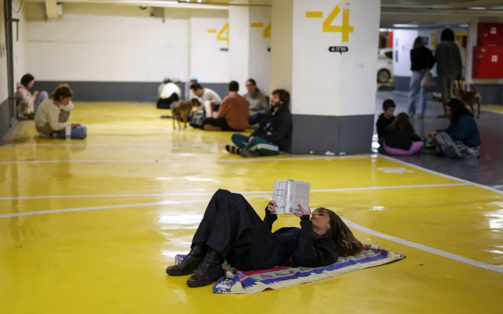 Des personnes se réfugient à Tel Aviv le 28 février 2026 (Crédit : Ilia YEFIMOVICH / AFP)