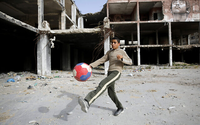 Un jeune garçon joue au football à côté d'une fresque murale peinte par l'artiste palestinien Ali Al-Jabali sur les vestiges d'un bâtiment partiellement détruit pendant la guerre de 2014 entre Israël et le Hamas, à Gaza, mardi 30 avril 2019. (AP Photo/Hatem Moussa) Un jeune garçon joue au football à côté d'une fresque murale peinte par l'artiste palestinien Ali Al-Jabali sur les vestiges d'un bâtiment partiellement détruit pendant la guerre de 2014 entre Israël et le Hamas, à Gaza, mardi 30 avril 2019. (AP Photo/Hatem Moussa)