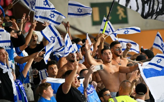 Les supporters israéliens encouragent leur équipe avant le match de qualification pour la Coupe du monde de football entre Israël et l'Italie, dans le groupe I, au stade Nagyerdei de Debrecen, en Hongrie, le lundi 8 septembre 2025. (Crédit : AP Photo/Denes Erdos)