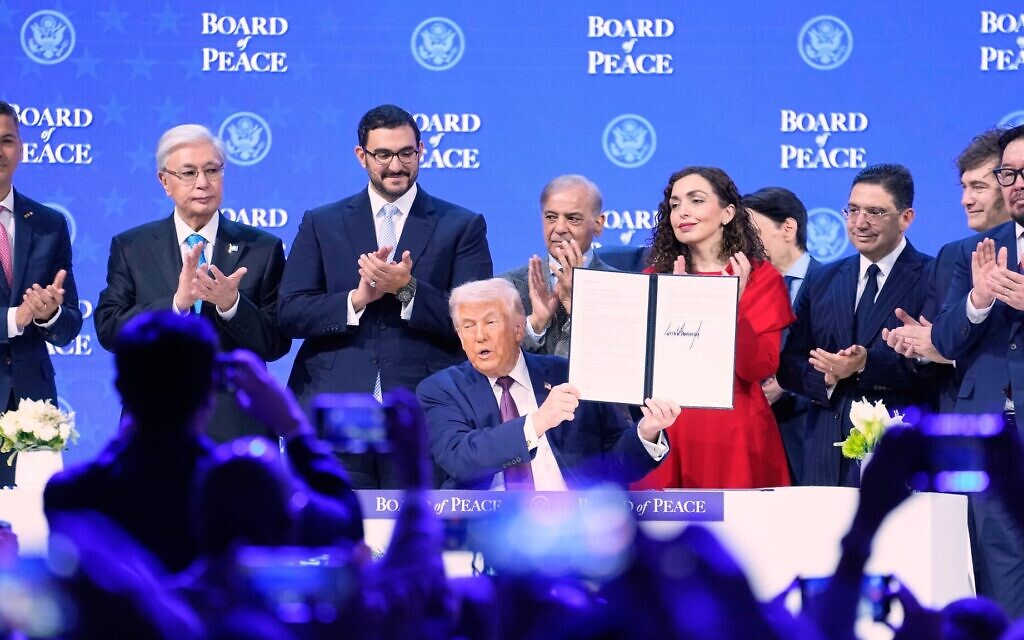 Le président Donald Trump brandissant la charte lors d'une cérémonie de signature dans le cadre de son initiative « Conseil de Paix » lors de la réunion annuelle du Forum économique mondial, à Davos, en Suisse, le 22 janvier 2026. (Crédit : Markus Schreiber/AP)