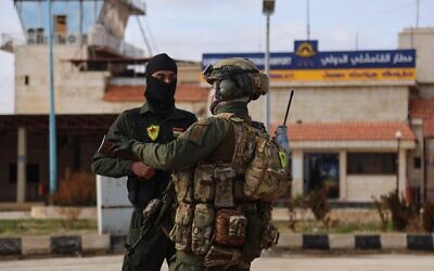 Des agents de sécurité interne des Forces démocratiques syriennes (FDS) dirigées par les Kurdes montant la garde alors qu'un convoi des forces de sécurité du ministère syrien de l'Intérieur arrive à l'aéroport international de Qamishli, dans l'est de la Syrie, dans le cadre d'un accord visant à stabiliser le cessez-le-feu, le 8 février 2026. (Crédit : Baderkhan Ahmad/AP)