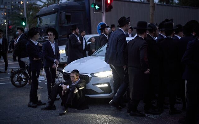 Des ultra-orthodoxes bloquant une route lors d'une manifestation contre la conscription militaire, à Bnei Brak, le 9 février 2026. (Crédit : Leo Correa/AP)