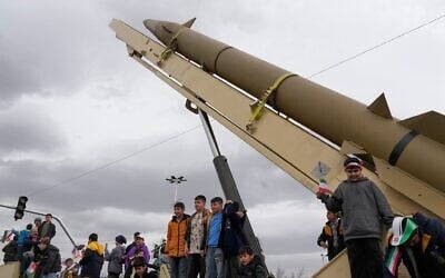 Des enfants se tenant debout sur un lanceur de missile de fabrication iranienne lors d'un rassemblement annuel marquant la Révolution islamique de 1979, sur la place Azadi, ou place de la Liberté, à Téhéran, en Iran, le 11 février 2026. (Crédit : Vahid Salemi/AP)