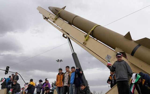 Des enfants se tenant debout sur un lanceur de missile de fabrication iranienne lors d'un rassemblement annuel marquant la Révolution islamique de 1979, sur la place Azadi, ou place de la Liberté, à Téhéran, en Iran, le 11 février 2026. (Crédit : Vahid Salemi/AP) Des enfants se tenant debout sur un lanceur de missile de fabrication iranienne lors d'un rassemblement annuel marquant la Révolution islamique de 1979, sur la place Azadi, ou place de la Liberté, à Téhéran, en Iran, le 11 février 2026. (Crédit : Vahid Salemi/AP)
