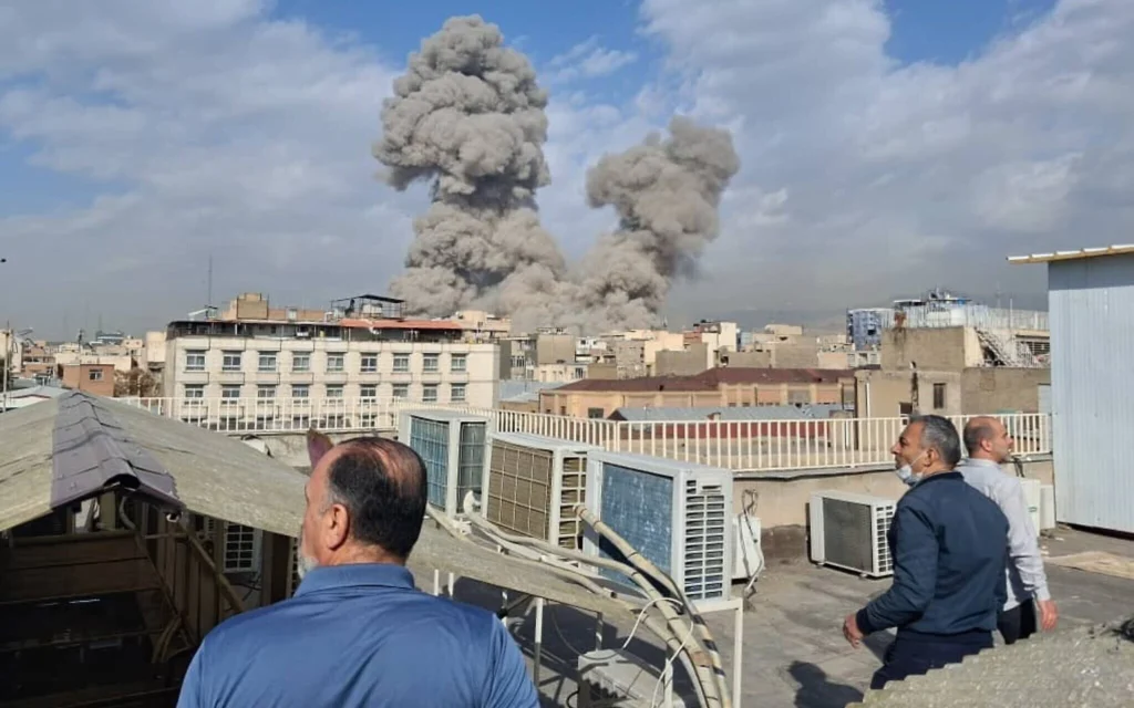 Des habitants observent la fumée s'élever dans le ciel après une explosion à Téhéran, en Iran, le 28 février 2026. (Crédit : AP)