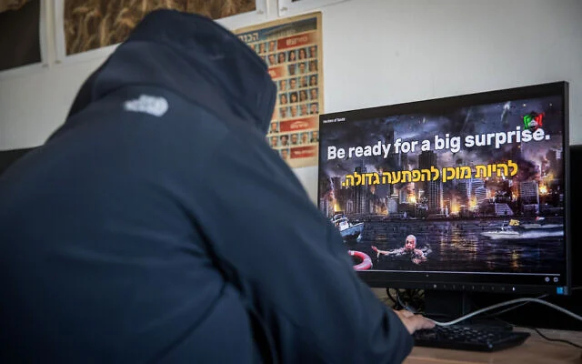 Illustration : Un homme regarde une vidéo sur un site israélien piratée pendant la nuit par un groupe de hackers iranien se faisant appeler « Hackering Saviours », dans un bureau à Jérusalem le 21 mai 2020. (Yonatan Sindel/Flash90) Illustration : Un homme regarde une vidéo sur un site israélien piratée pendant la nuit par un groupe de hackers iranien se faisant appeler « Hackering Saviours », dans un bureau à Jérusalem le 21 mai 2020. (Yonatan Sindel/Flash90)
