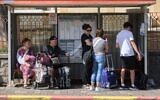 Des habitants de la ville de Kiryat Shmona, dans le nord du pays, attendant à un arrêt de bus pour être évacués, en raison des attaques quotidiennes du groupe terroriste chiite libanais du Hezbollah, le 22 octobre 2023. (Crédit : Ayal Margolin/Flash90)