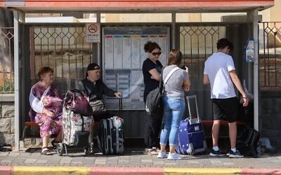 Des habitants de la ville de Kiryat Shmona, dans le nord du pays, attendant à un arrêt de bus pour être évacués, en raison des attaques quotidiennes du groupe terroriste chiite libanais du Hezbollah, le 22 octobre 2023. (Crédit : Ayal Margolin/Flash90)