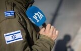 Un soldat israélien servant à la radio de l'armée tient un micro à Jérusalem, le 22 décembre 2025. (Crédit : Yonatan Sindel/Flash90)
