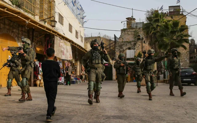 Illustration : des soldats de l'armée israélienne assurent la sécurité d'une visite guidée dans la ville d'Hébron, en Cisordanie, le 14 février 2026. (Crédit : Wisam Hashlamoun/Flash90)