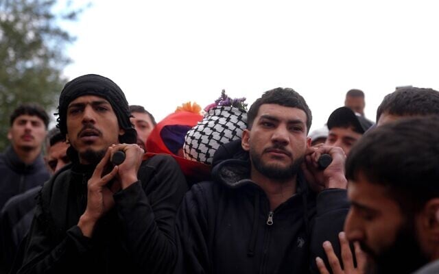 Des personnes transportant le corps de Nasrallah Muhammad Abu Siyam, un Palestino-Américain de 19 ans qui aurait été abattu par des résidents d'implantations, lors de ses funérailles, dans le village de Mukhmas, en Cisjordanie, à l'est de Ramallah, le 19 février 2026. (Crédit : Flash90)