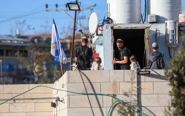 Des Juifs ayant emménagé, aperçus sur un toit dans la ville de Hébron, en Cisjordanie, le 20 février 2026. (Crédit : Wisam Hashlamoun/Flash90)