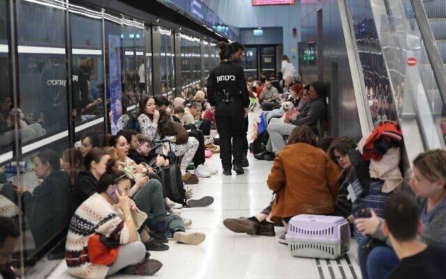 Des personnes réfugiées dans une station de train à Ramat Gan, pendant les attaques de missiles en cours depuis l'Iran, le 28 février 2026. (Crédit : Oren Cohen/Flash90)