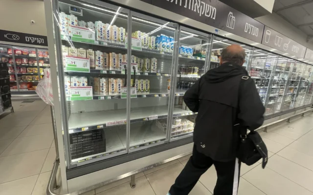 Un client passe devant des rayons vides marqués « lait à prix contrôlé » dans un supermarché Shufersal de la ville de Haïfa, dans le nord du pays, le 3 février 2026. (Crédit : Sue Surkes/Times of Israel)