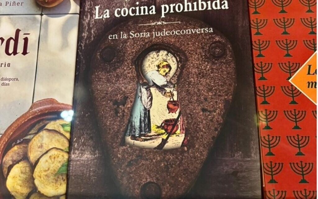 Des livres de cuisine juive espagnole, et notamment un recueil contemporain de recettes de cuisine juive interdite suite à l'Expulsion des Juifs d'Espagne exposés dans une cave voûtée médiévale de la Casa de Sefarad, à Cordoue, en Espagne, le 27 décembre 2025 (Rachel Bellegy-Chazelas).
