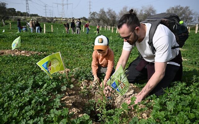 Un père et son fils plantant un arbre dans la forêt de Ben Shemen, dans le centre d'Israël, pour marquer Tou BiShvat, le 2 février 2026. (Crédit : Jorge Novominsky, Fonds National Juif)