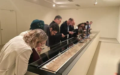 Le vernissage de l'exposition « Une voix venue du désert – Le grand rouleau d'Isaïe » a eu lieu au Musée d'Israël le 23 février 2026. Sur l'image, on voit des curieux admirer le parchemin, long de sept mètres, dans une pièce spécialement climatisée. (Rossella Tercatin/Times of Israel)