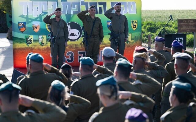 De gauche à droite : Le brigadier général Barak Hiram, commandant sortant de la division Gaza, le major général Yaniv Asor, chef du Commandement du Sud, et le brigadier général Liron Betito, nouveau commandant de la division Gaza, lors d'une cérémonie de passation de pouvoir, près de la frontière avec Gaza, le 22 février 2026. (Crédit : Armée israélienne)