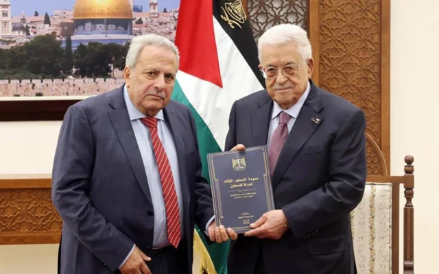 Le dirigeant de l'Autorité palestinienne, Mahmoud Abbas, recevant un projet de constitution provisoire de l'État palestinien des mains du conseiller Muhammad al-Hajj Qasim, à Ramallah, le 5 février 2026. (Crédit : Wafa)