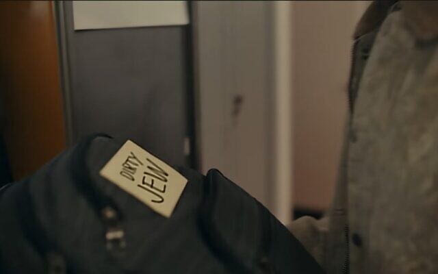 Un adolescent trouve un post-it avec les mots "sale juif" sur son sac à dos dans la publicité diffusée lors du Super Bowl 2026 par la Blue Square Alliance de Robert Kraft. (Crédit : Capture d'écran via JTA)