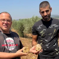 Le professeur Ran Barkai de l'Université de Tel Aviv (à gauche) et Muataz Shalata, un habitant de Sakhnin, tiennent des haches en pierre vieilles de 500 000 ans, fabriquées avec des matériaux spéciaux présentant des caractéristiques géologiques uniques. La découverte a été annoncée en mars 2026. (Université de Tel Aviv)