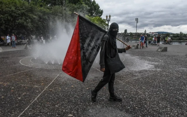 Des Antifas passent devant une fontaine lors d'un rassemblement de l'alt-right le 17 août 2019, à Portland, dans l'Oregon. (Crédit : Stephanie Keith/Getty Images/AFP)